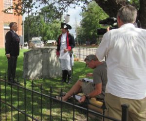 A man with a Lafayette reenactor, observer by a man directing and a man with a videocamera
