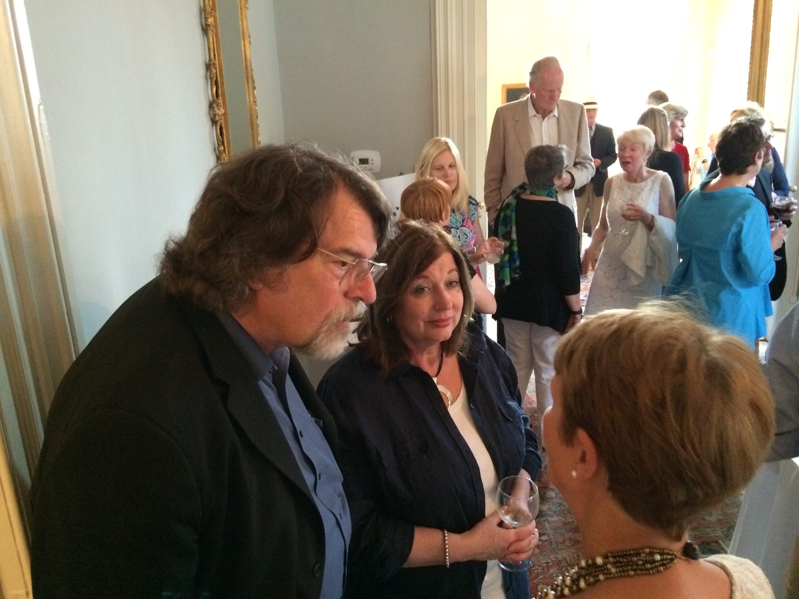 A photo of a crowd of people socializing. In the foreground two women are talking with a man. On May 23, 2015, the Lafayette Society hosted a group of French musicians touring the United States with Chris Brubeck, whose father founded the Dave Brubeck Five. Brubeck and Guillaume Saint-James composed a symphony “Brothers in Arts: 70 Years of Liberty,” which had its American premier in Fayetteville on July 4.